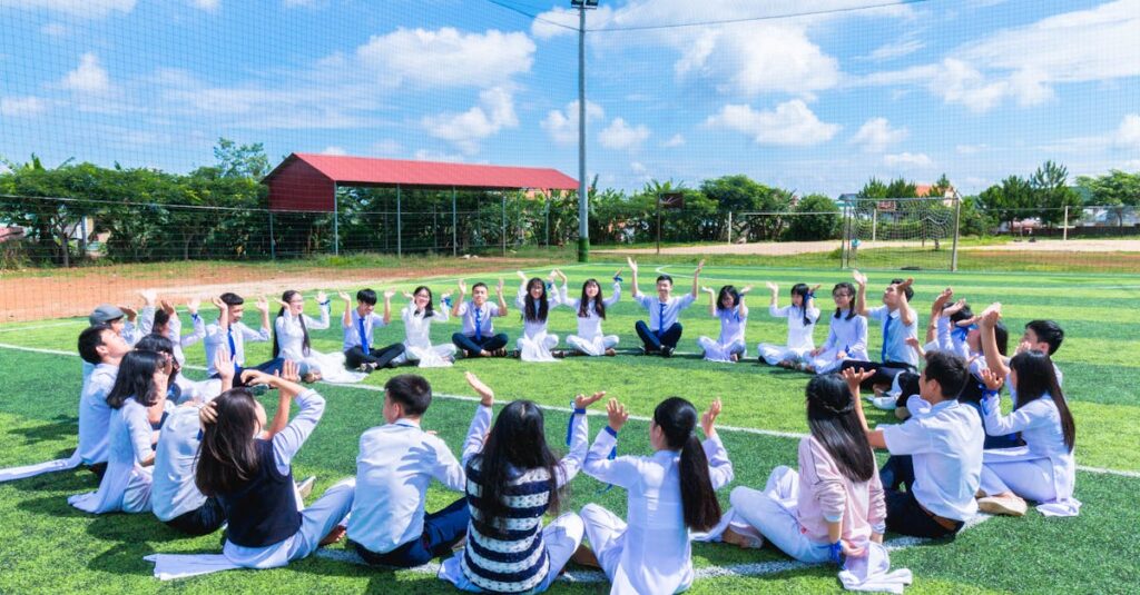 People Sitting on Green Lawn Grass While Doing Hands Up at Daytime