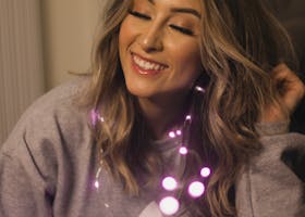 Cheerful young woman with glowing garland