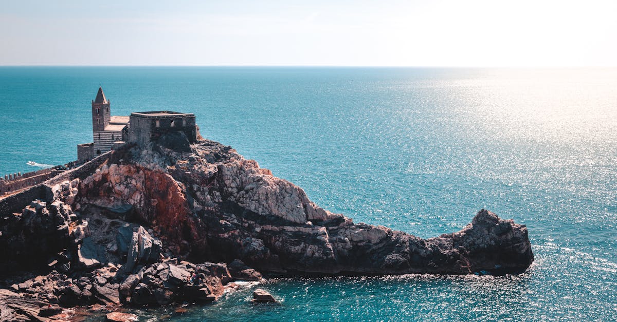 Breathtaking view of the Church of St. Peter in Portovenere, Liguria, overlooking the shimmering sea under the summer sun.