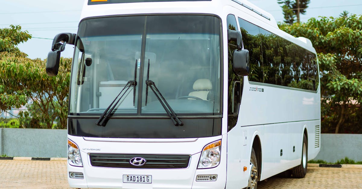 Front view of a modern white bus parked in an outdoor setting.