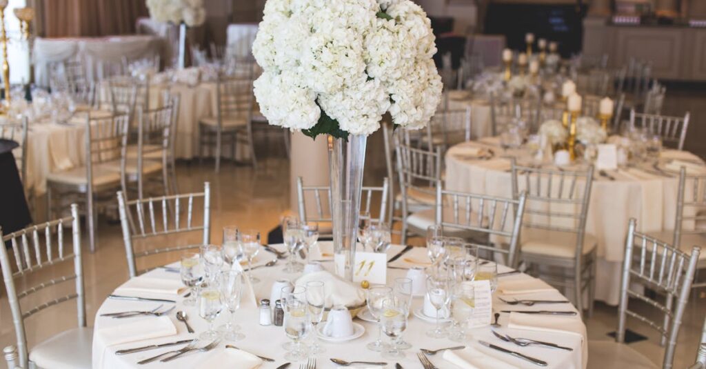 Beautifully decorated wedding reception table with elegant floral centerpiece and silverware.