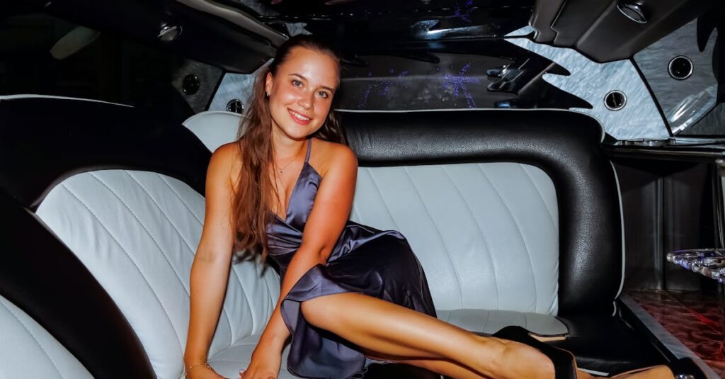 Caucasian woman in a blue dress lounging inside a luxurious car interior.