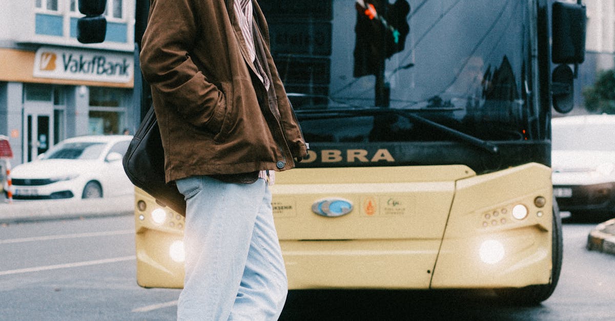 Man standing on city street near bus, capturing urban lifestyle.