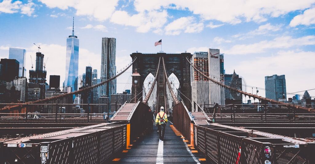 Iconic Brooklyn Bridge view with New York City skyline and construction worker.