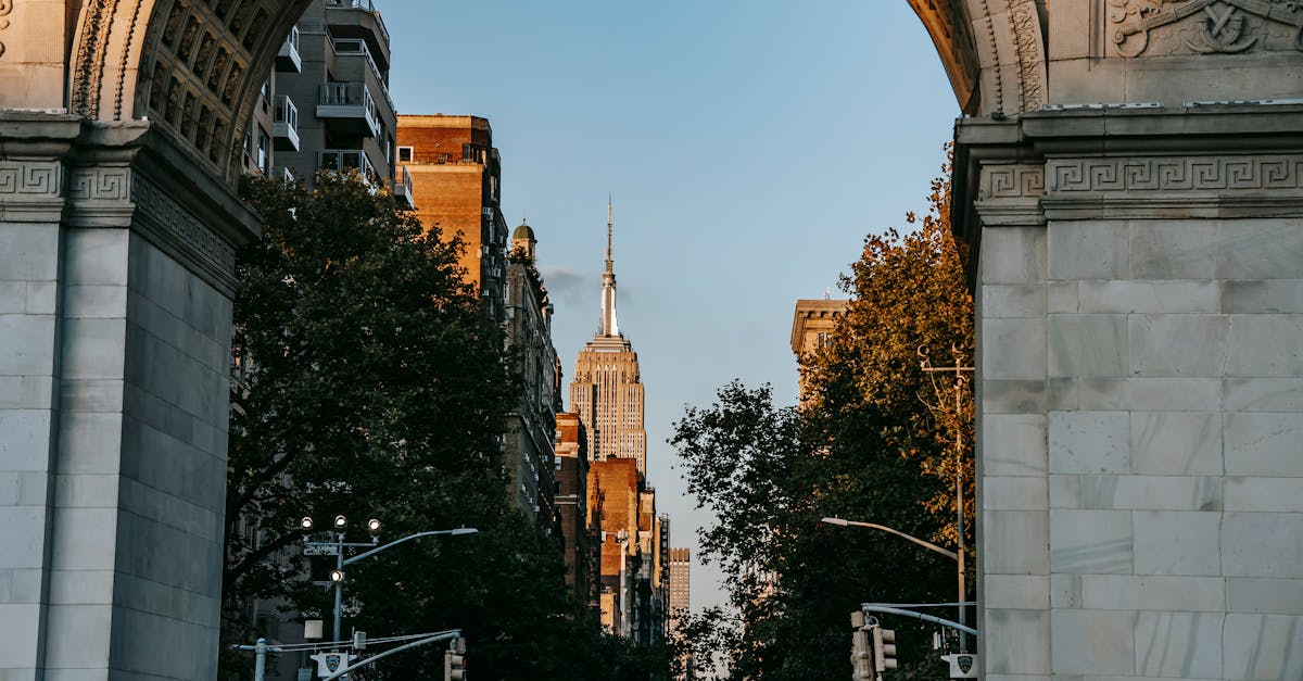 View through ancient arch on street leading to famous skyscraper in New York City in sunny day