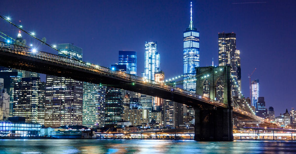 Stunning view of the Brooklyn Bridge and New York City skyline illuminated at night.