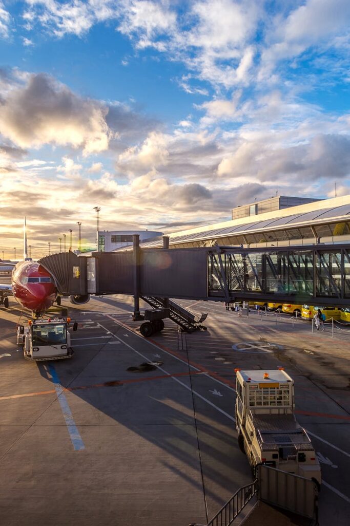 A vibrant sunset at Copenhagen Airport with airplanes and bustling activity.