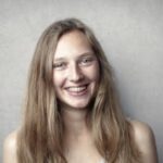 Portrait of a happy young woman with braces smiling at the camera.