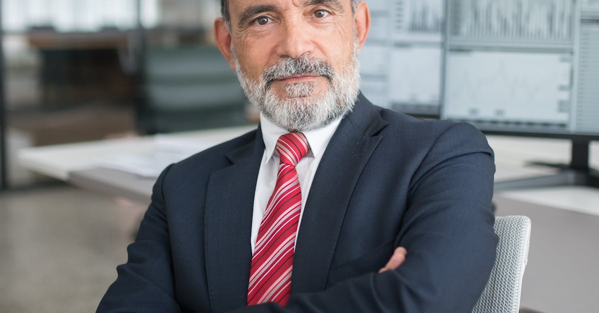 Professional businessman sitting confidently in a modern office with multiple screens displaying data.