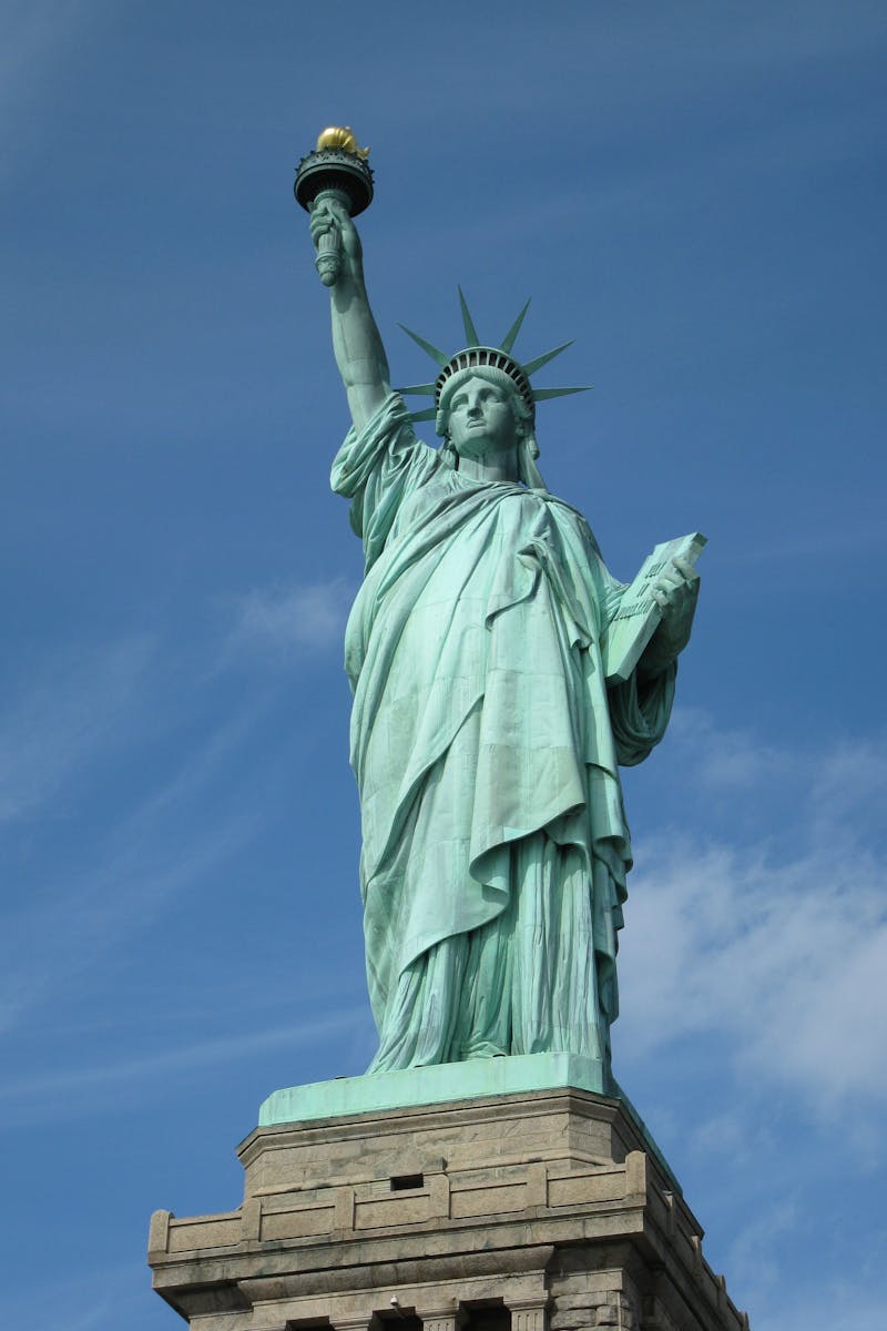 The Statue of Liberty serves as a symbol of freedom against a clear blue sky in New York City.